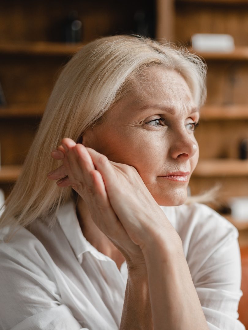 Stressed sad tired exhausted caucasian middle-aged mature businesswoman freelancer relaxing on the couch sofa, thinking about family marriage work problems at work office