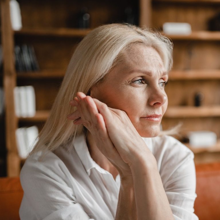 Stressed sad tired exhausted caucasian middle-aged mature businesswoman freelancer relaxing on the couch sofa, thinking about family marriage work problems at work office