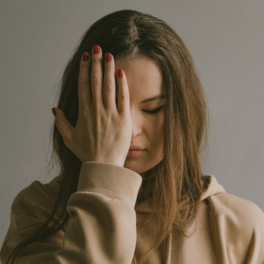 a woman covering her face with her hands