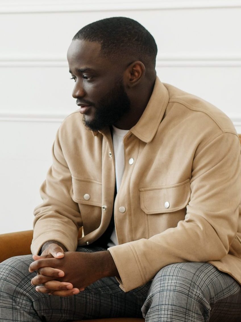 The therapist takes notes while talking to a depressed male patient and talks to an African American patient. Desperate black man suffering from nervous breakdown or depression having a session with a psychologist.